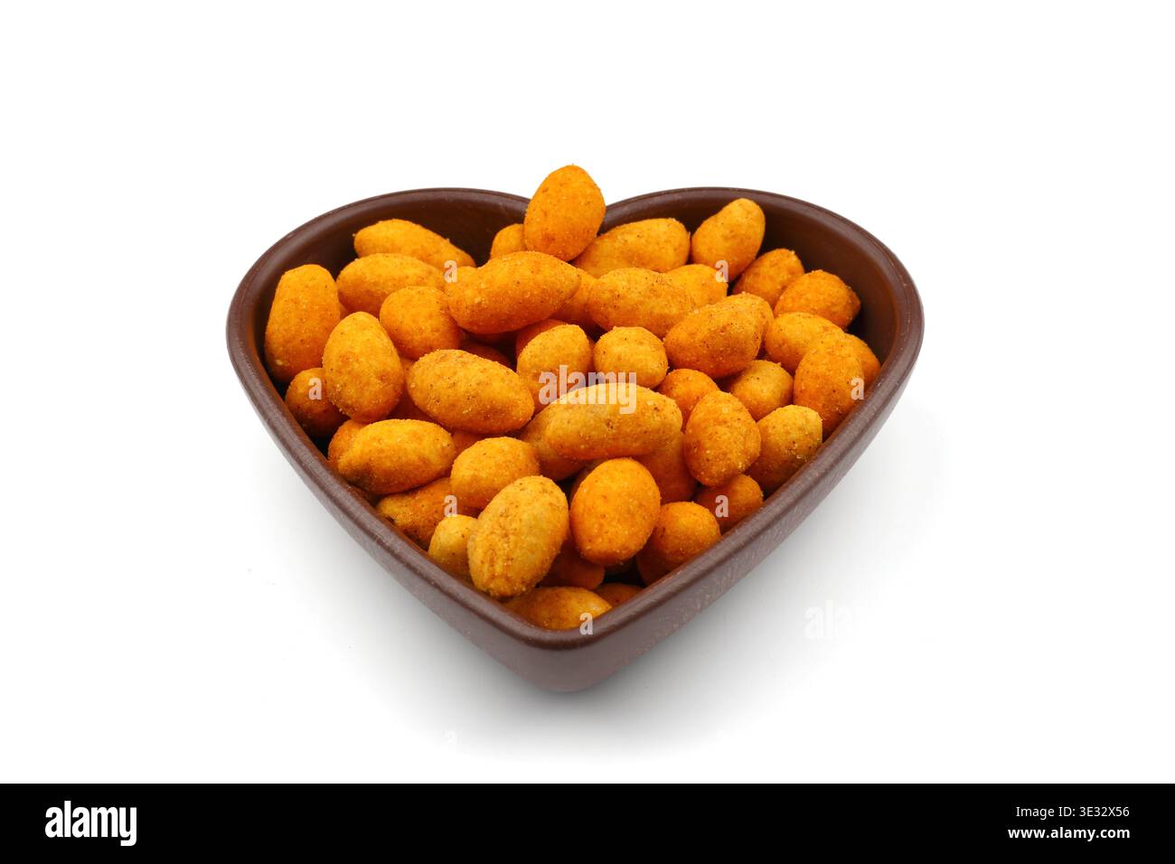 Crunchy Coated Peanuts in a Heart Shaped Bowl Isolated on White Background Stock Photo