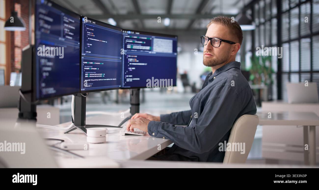 Dedicated Software Developer Concentrating On Programming And Problem Solving At Workstation Stock Photo