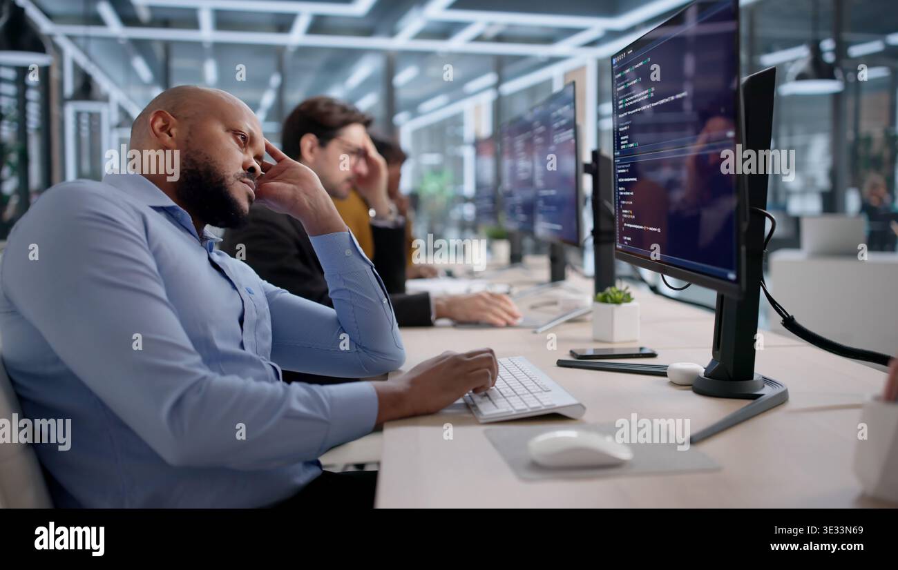 Frustrated Software Developers And Engineers Struggle With Broken Code While Working At Their Desks Stock Photo