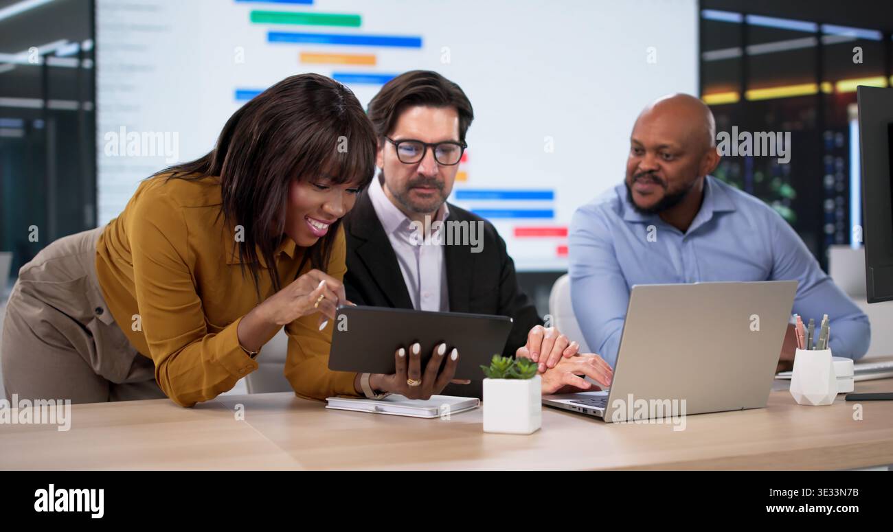 Diverse Team Collaborates Using Kanban Software, Planning Schedules On Laptops Stock Photo