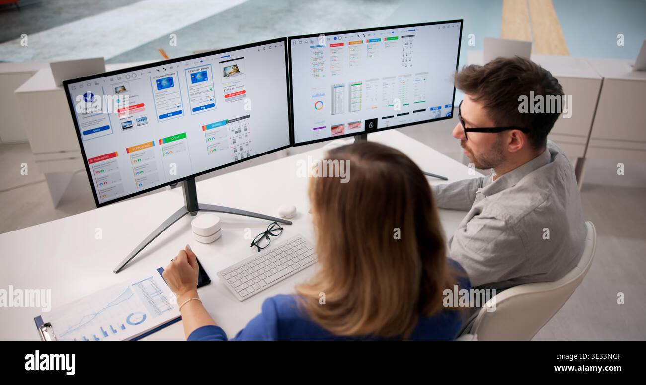 Creative Team Collaborating On App UI Design At Office Desk Stock Photo