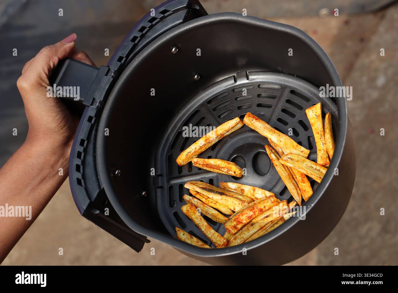 Air fryer tray with potato fries ready to be eaten after its airfried on the device Stock Photo