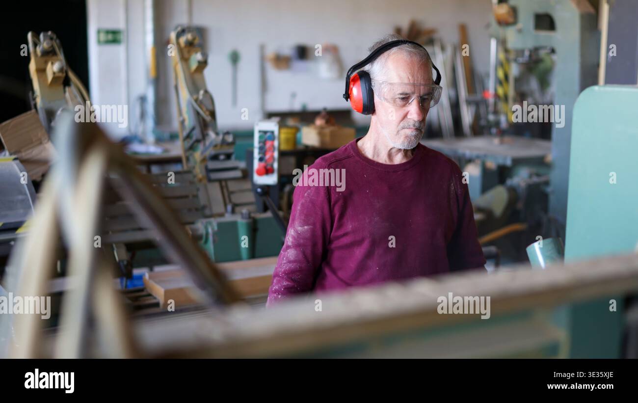 Experienced carpenter working with wood in workshop Stock Photo
