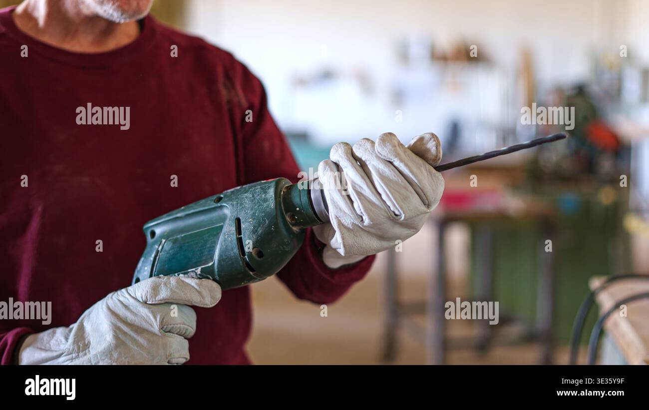 Craftsman inserting a drill bit into an electric drill Stock Photo