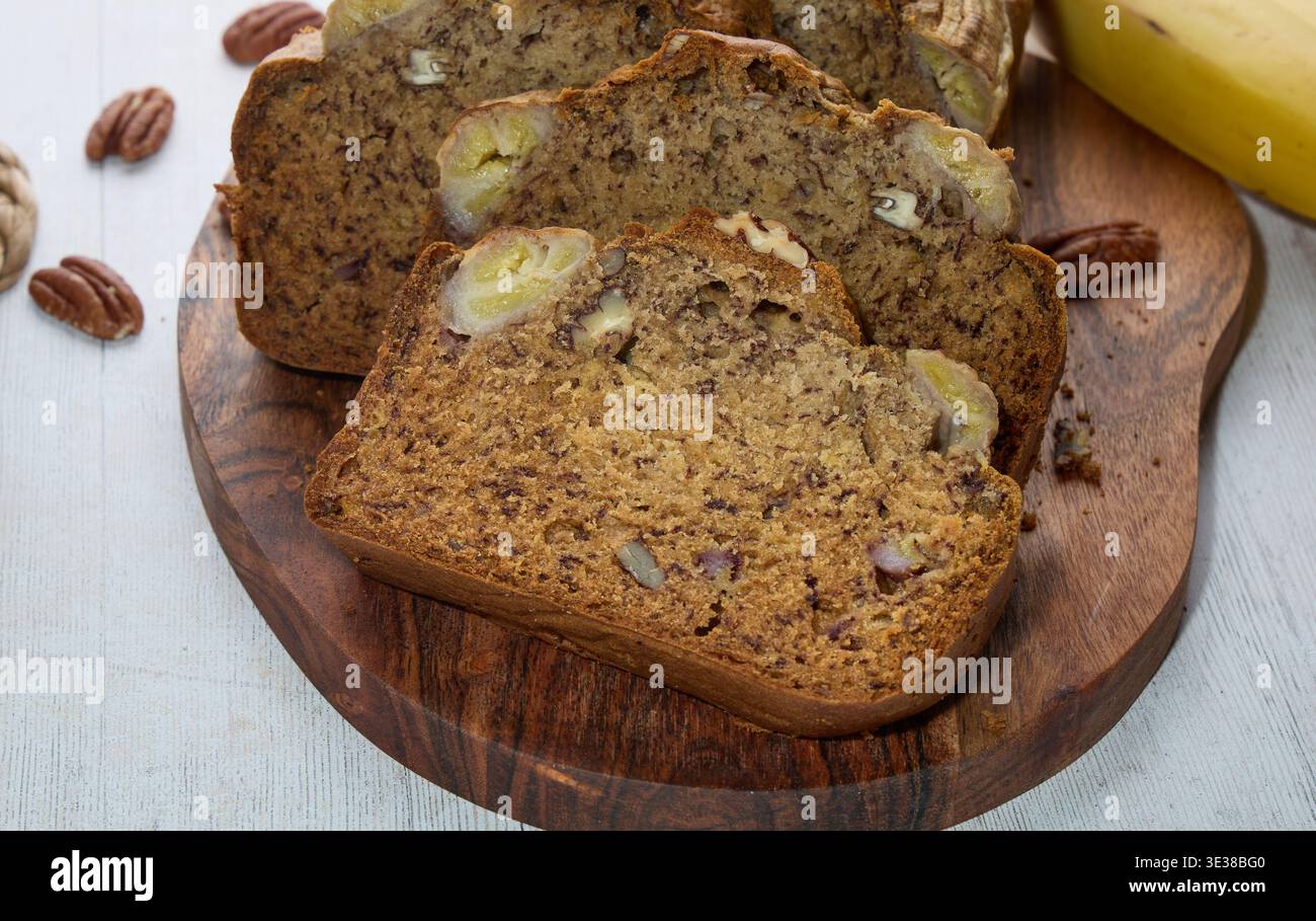 Homemade Banana Bread Slices with Nuts on Board Stock Photo