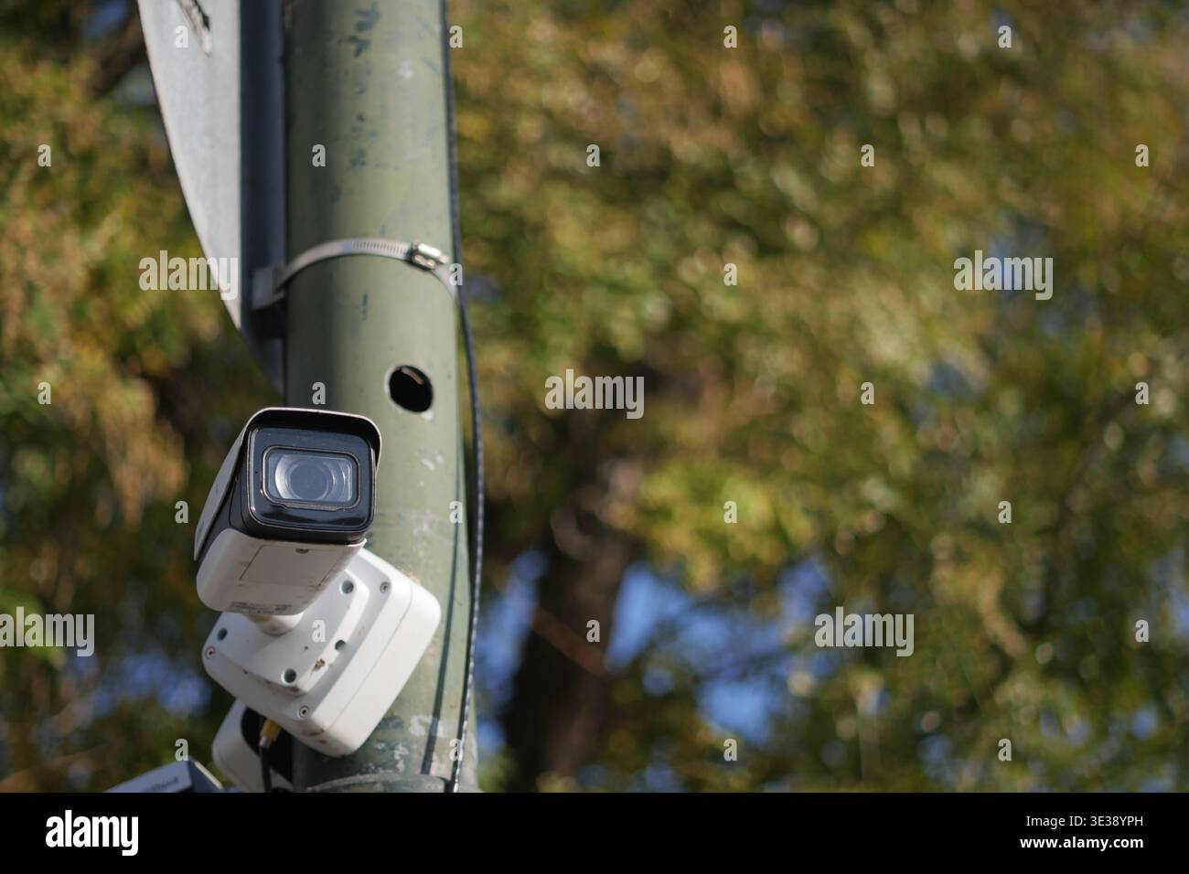 Security camera on a pole in a public area during daytime Stock Photo