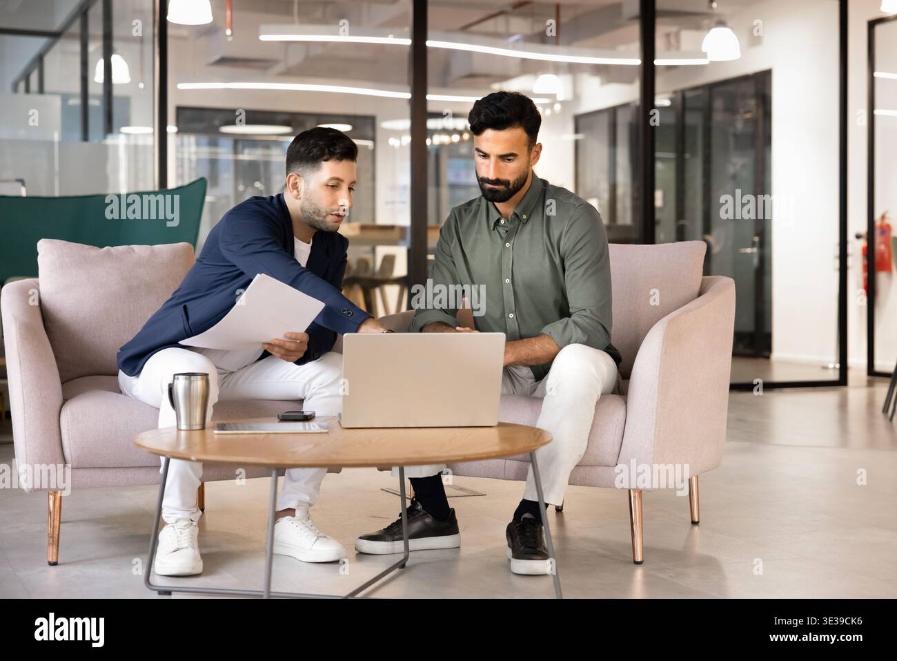 Two Middle Eastern male business colleagues reviewing information on laptop Stock Photo