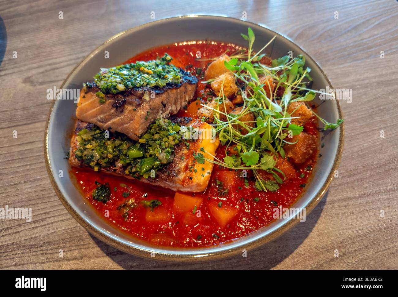 Grilled Salmon in Lebelebi stew with butternut squash, chickpea, harissa, rapini relish Stock Photo