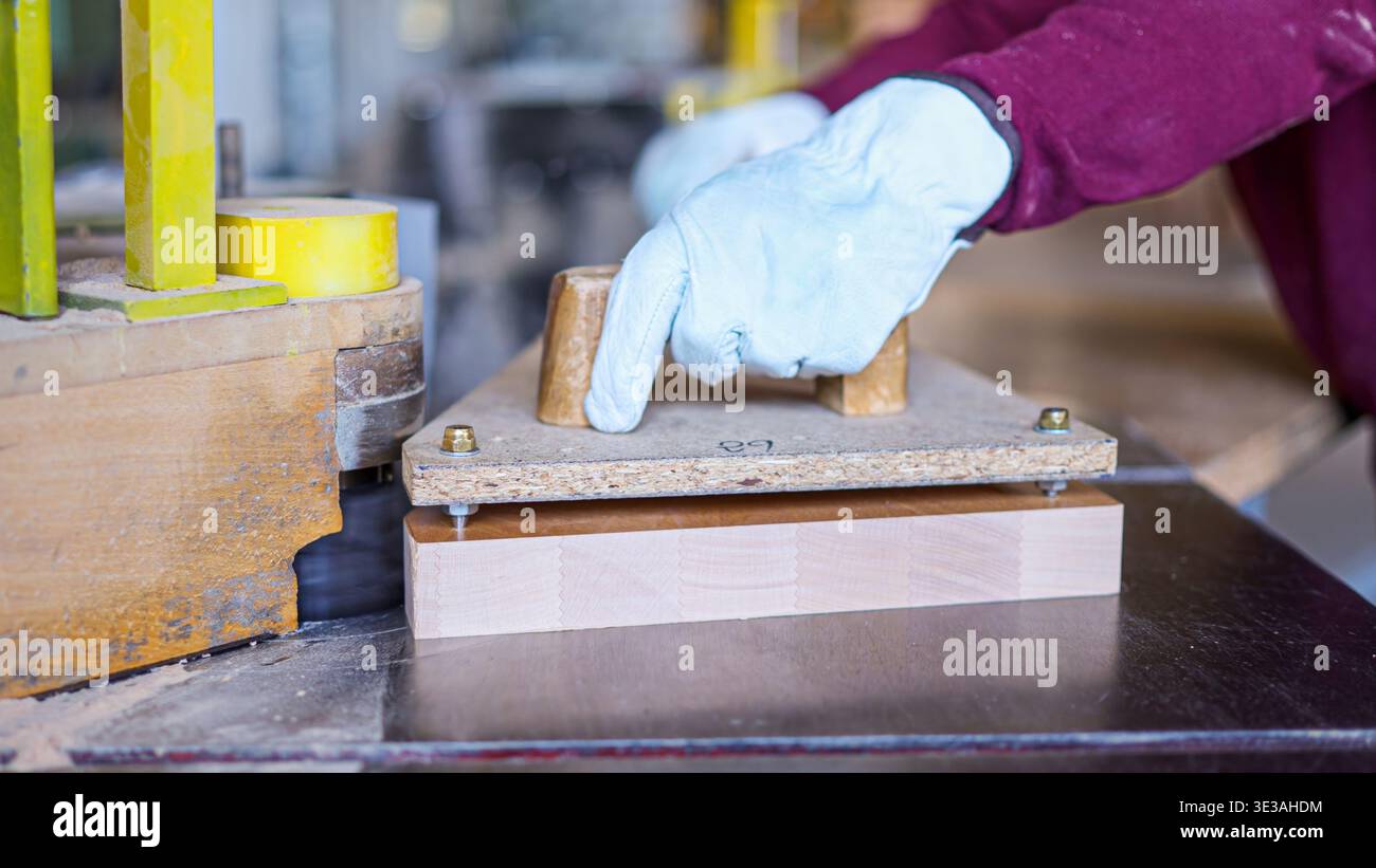 Carpenter cutting wood plank using spindler machine in workshop Stock Photo