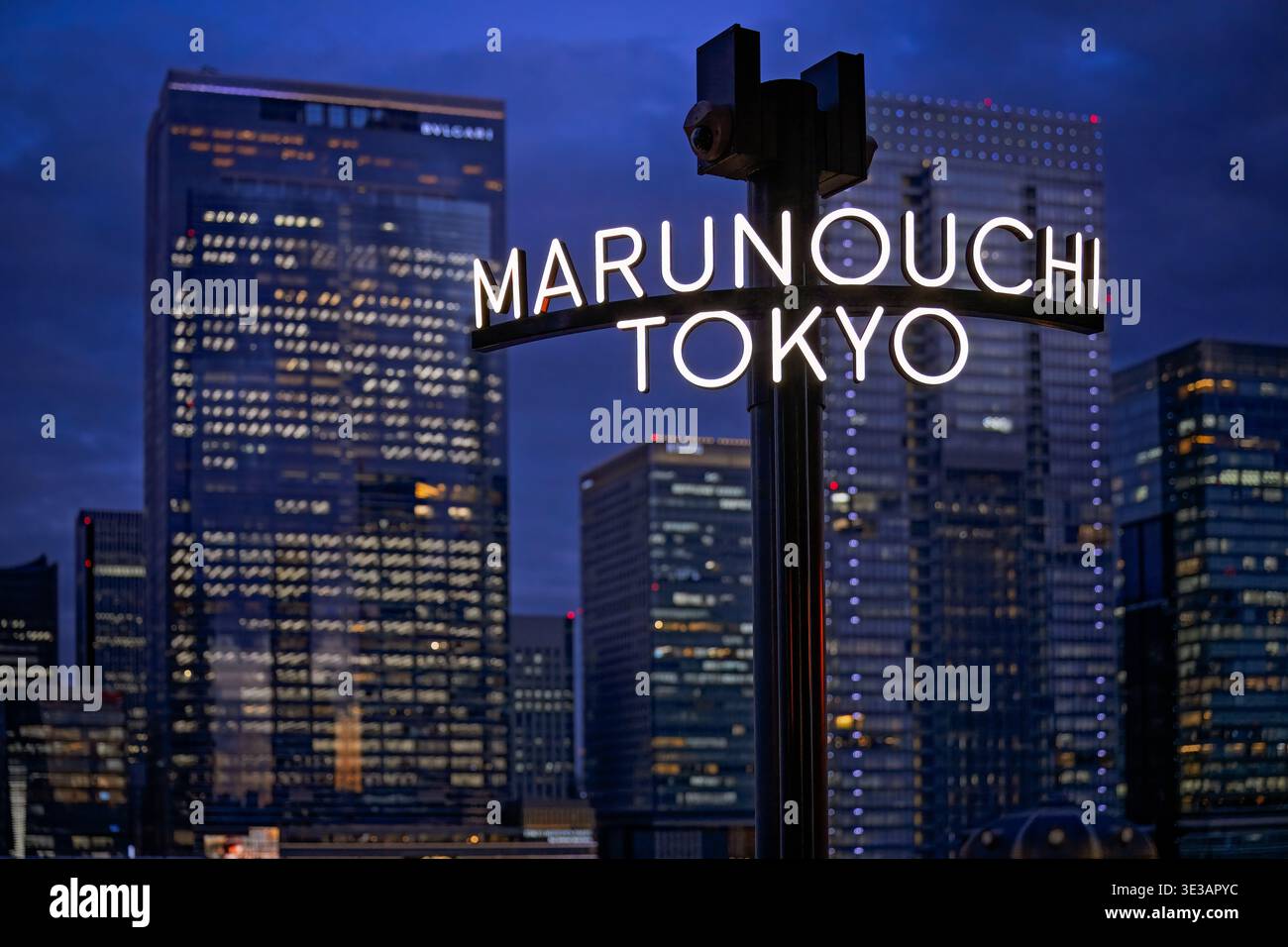 Tokyo Japan - January 2026: Marunouchi Tokyo sign illuminated at blue hour with skyscraper cityscape backdrop Stock Photo