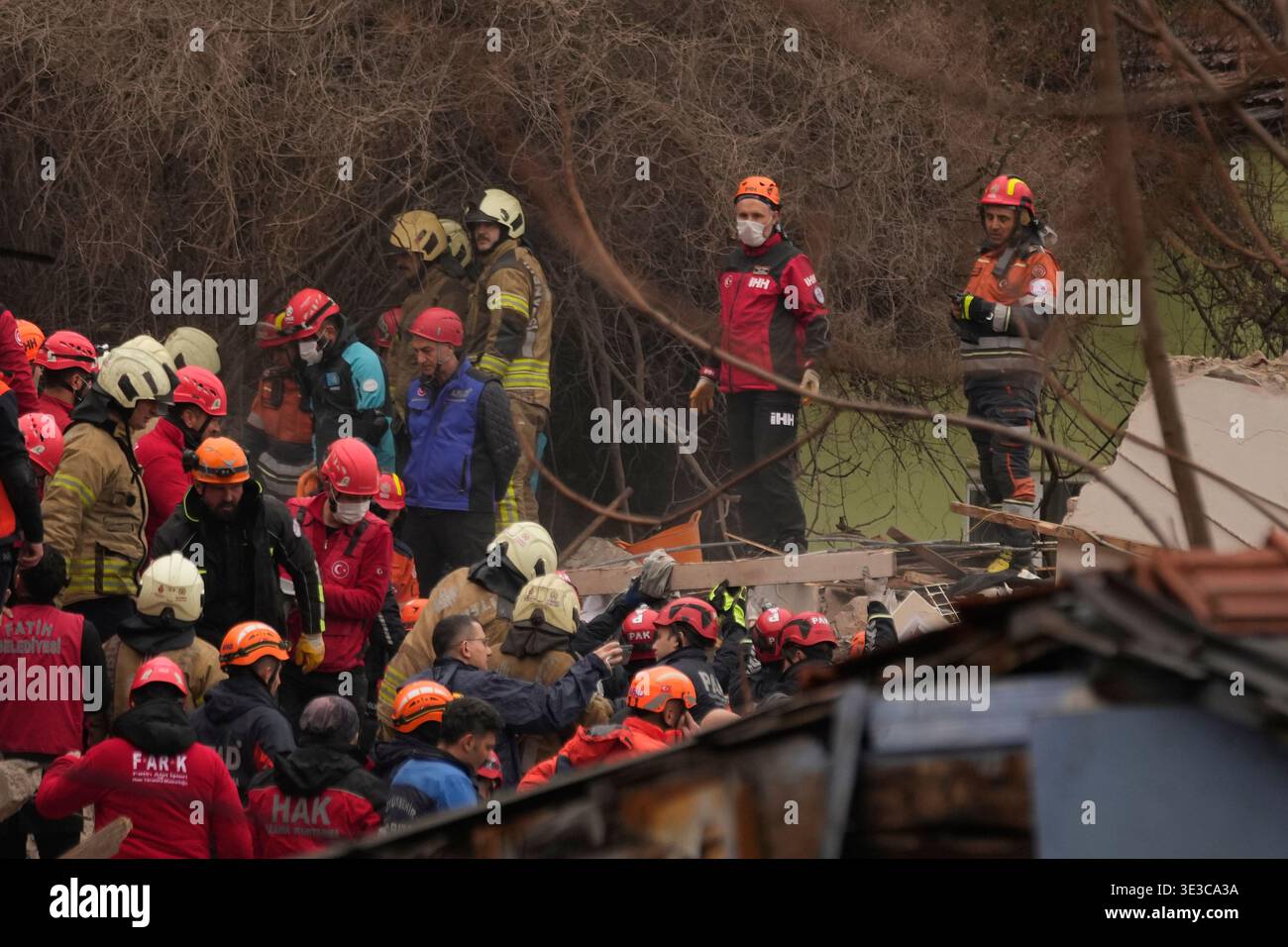 Rescue teams and firefighters search the site where two residential ...