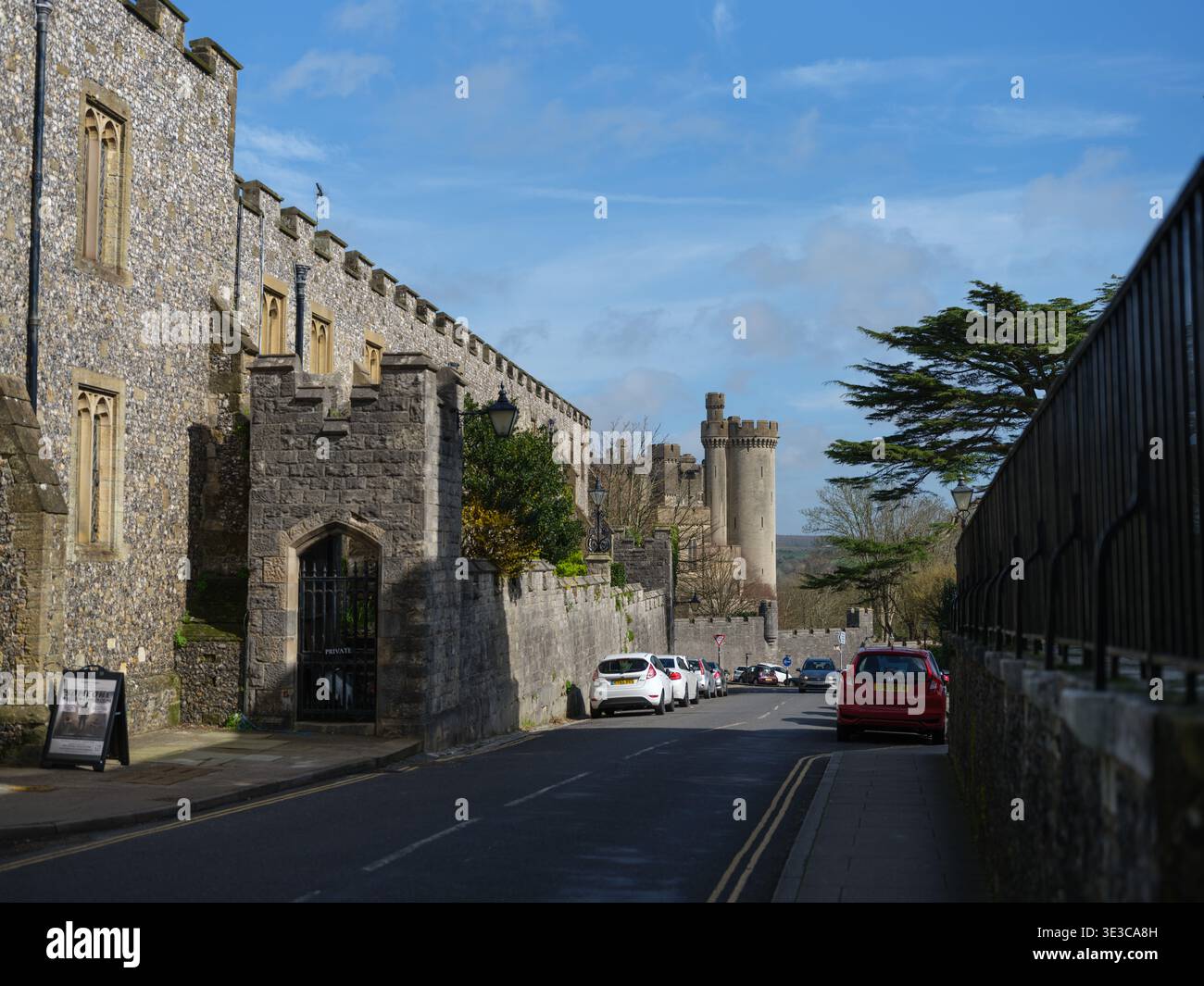 A street view looking down London Road towards Arundel Castle showing the Priory and Medieval structures of the West Sussex market Town. Stock Photo