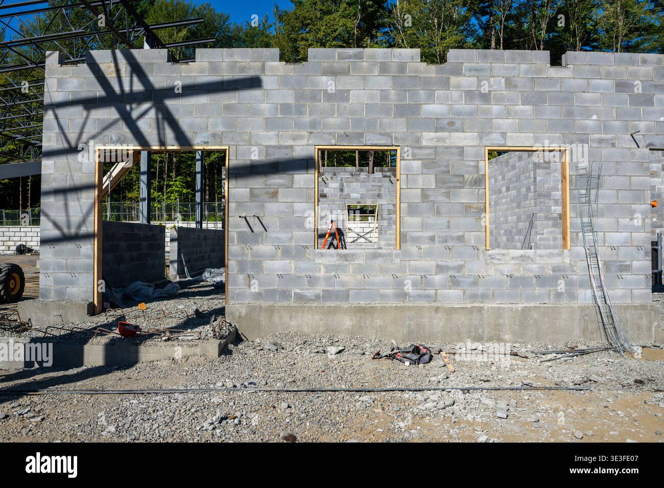 Concrete masonry unit, cmu, blocks wall under construction, with window and door openings. Stock Photo