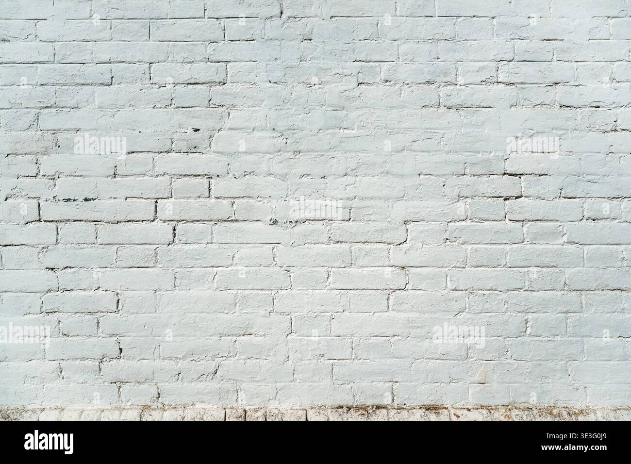 Whitewashed brick wall with subtle cracks and patina as background Stock Photo