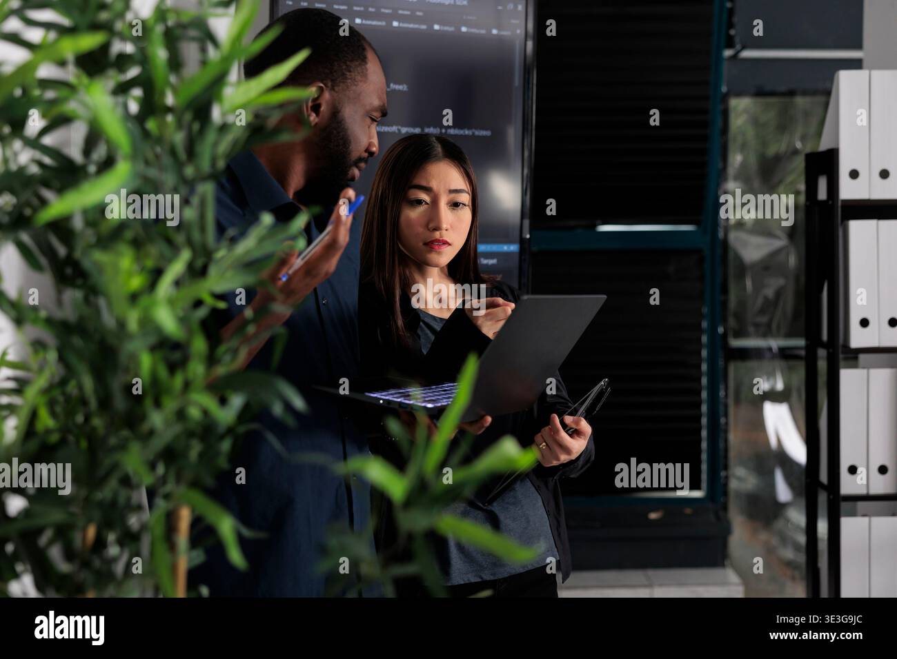 Multi ethnic team of system developers analyzing html code on laptop computer, checking artificial intelligence project. Programmers working on machine learning software, developing new interface. Stock Photo