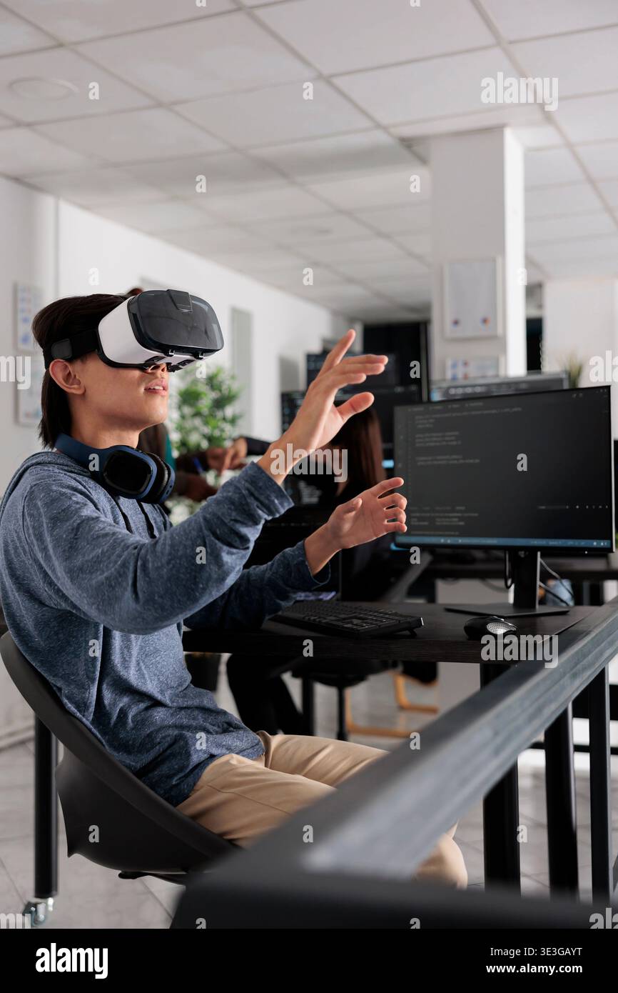 It programmer wearing virtual reality headset to code new server interface, analyzing cloud information on terminal window. Coder programming it database for internet software with vr goggles. Stock Photo