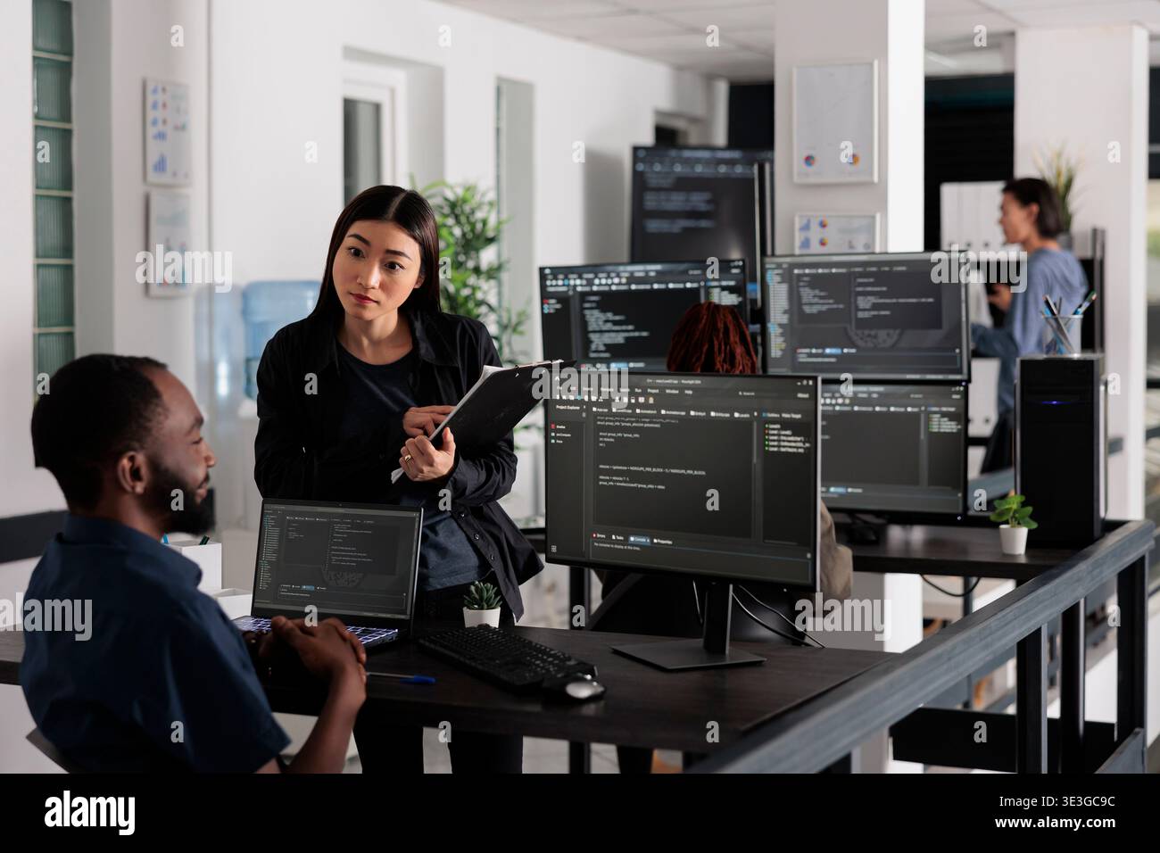 Team of system engineers working on software development with source code, looking at computer monitor. IT app developer writing ai algorithm in office, online cloud computing in agency Stock Photo