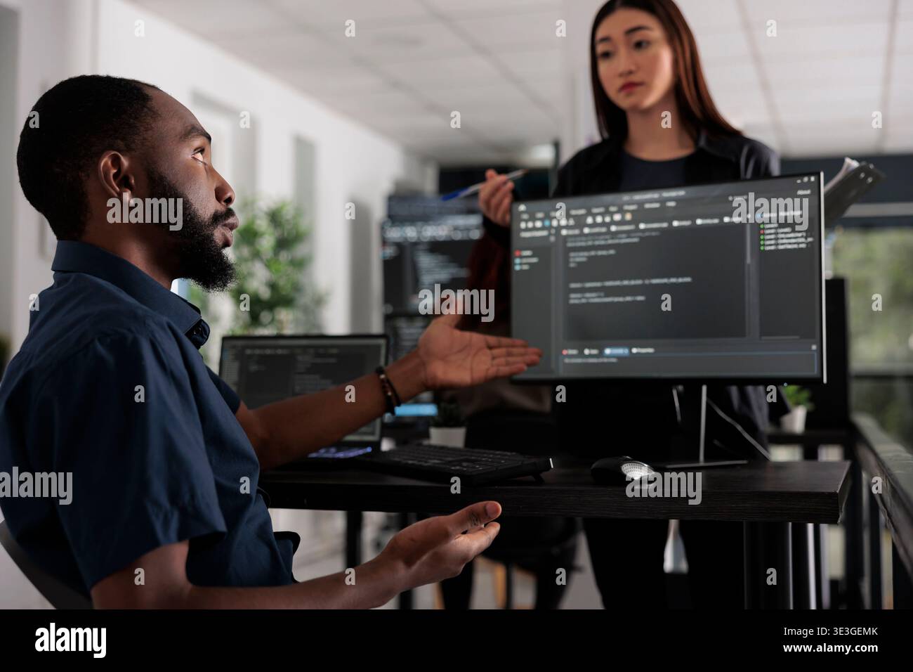 App developers working on temrinal window with html script and writing server code on computer, sitting in big data room. System engineer programming user interface in busy developing agency. Stock Photo