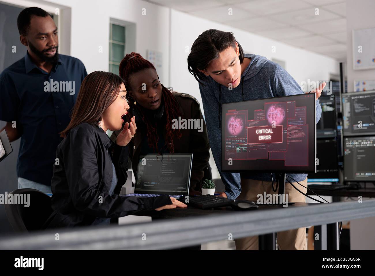 Team of software developers having web server hacked, reading critical error on computer display in agency. Multi ethnic programmers trying to solve hacking problem, firewall security. Stock Photo