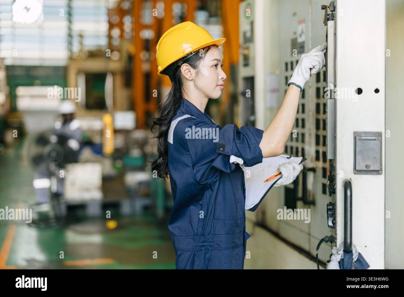 Professional young Asian Engineer woman working control operate CNC machine in heavy industry factory happy smiling good welfare Stock Photo