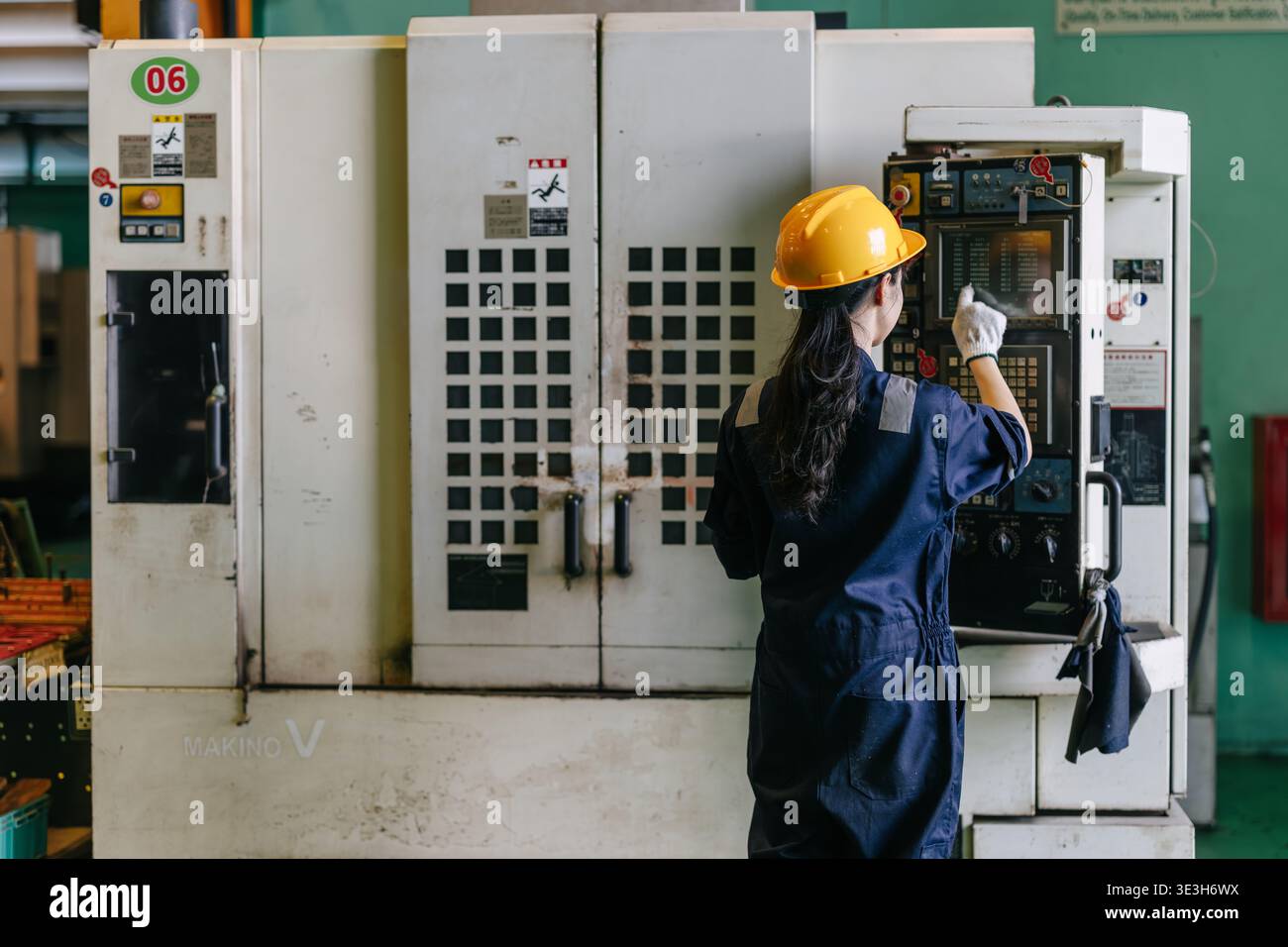 Professional young Asian Engineer woman working control operate CNC machine in heavy industry factory happy smiling good welfare Stock Photo