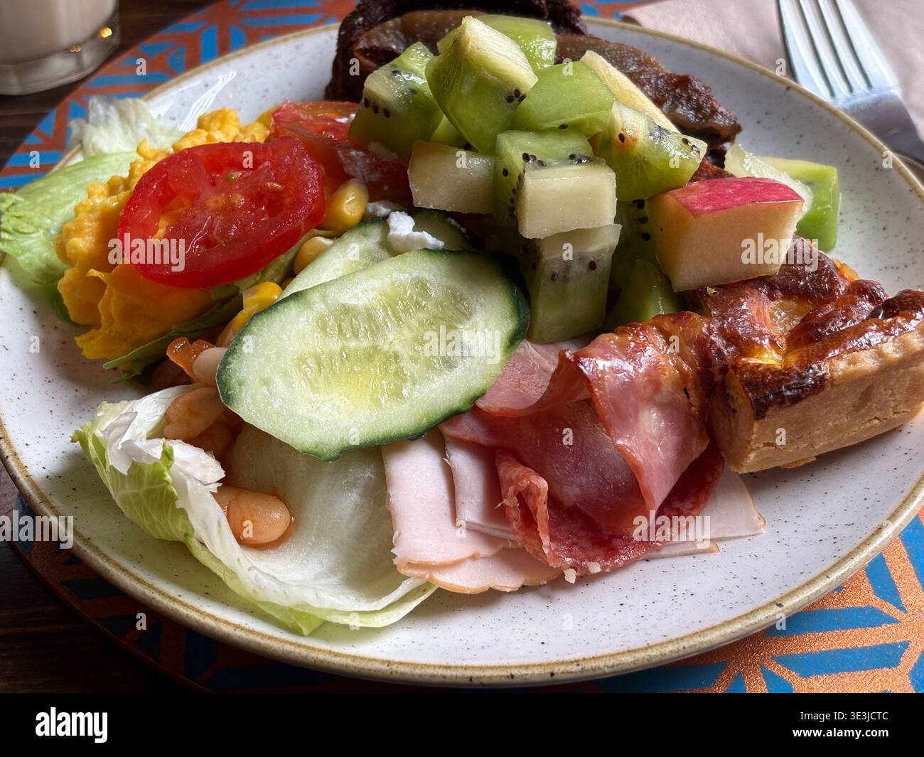 Hotel breakfast buffet in Rome, Italy. Serving scrambled eggs, cured meats, fruit, and quiche from an international selection. Stock Photo