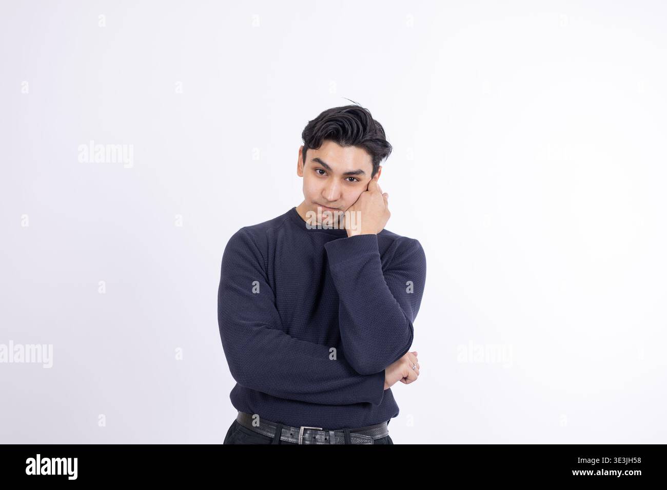 Tired young man leaning on his hand with a bored expression Stock Photo