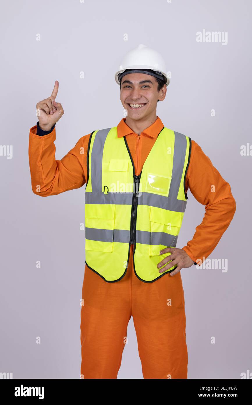 Construction worker in orange uniform pointing up in the studio Stock Photo