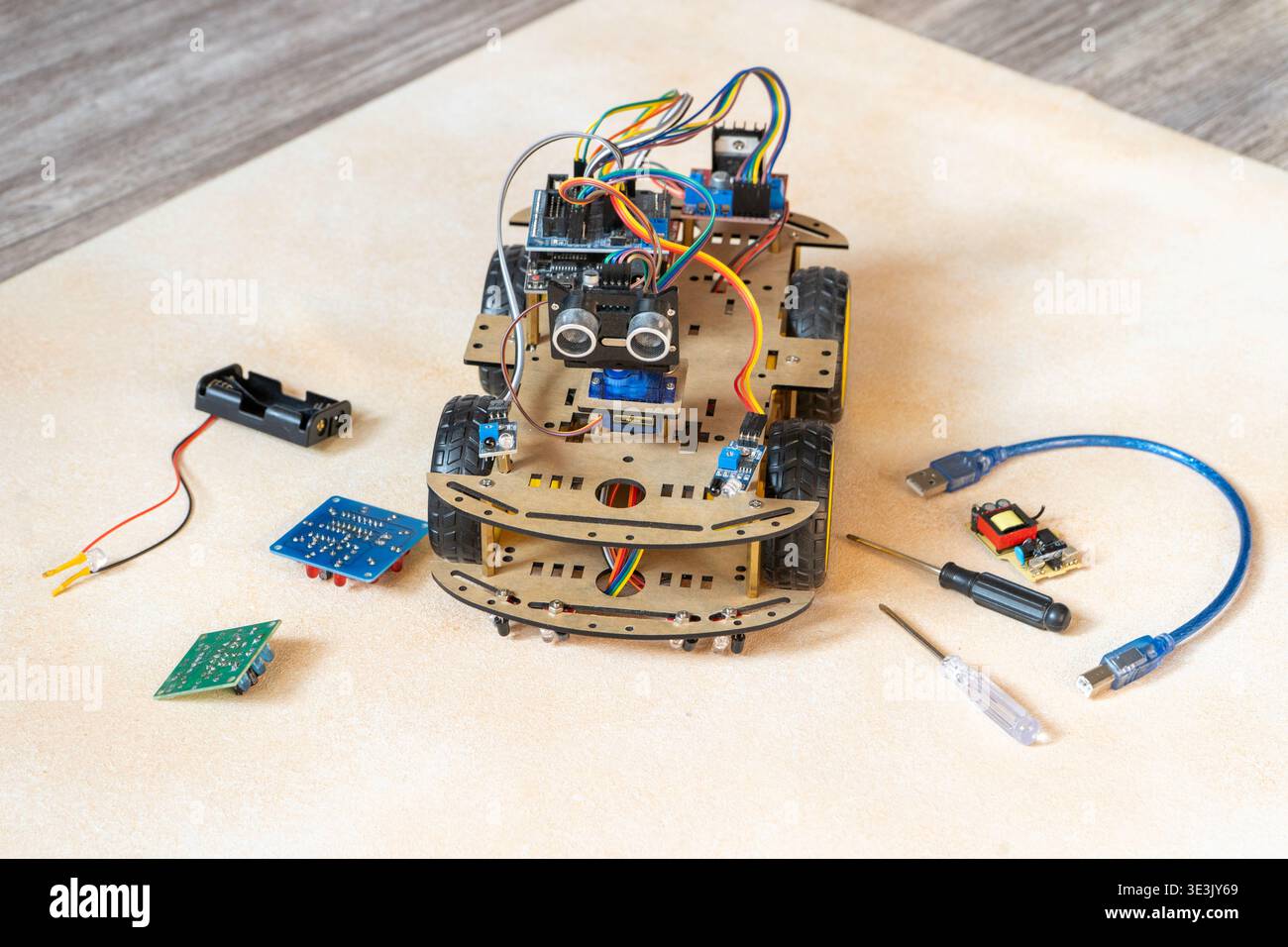 DIY robotic car kit with ultrasonic sensor, controller. Educational electronics project for STEM learning and robotics. Robot Assembly With Electronic Components. Stock Photo