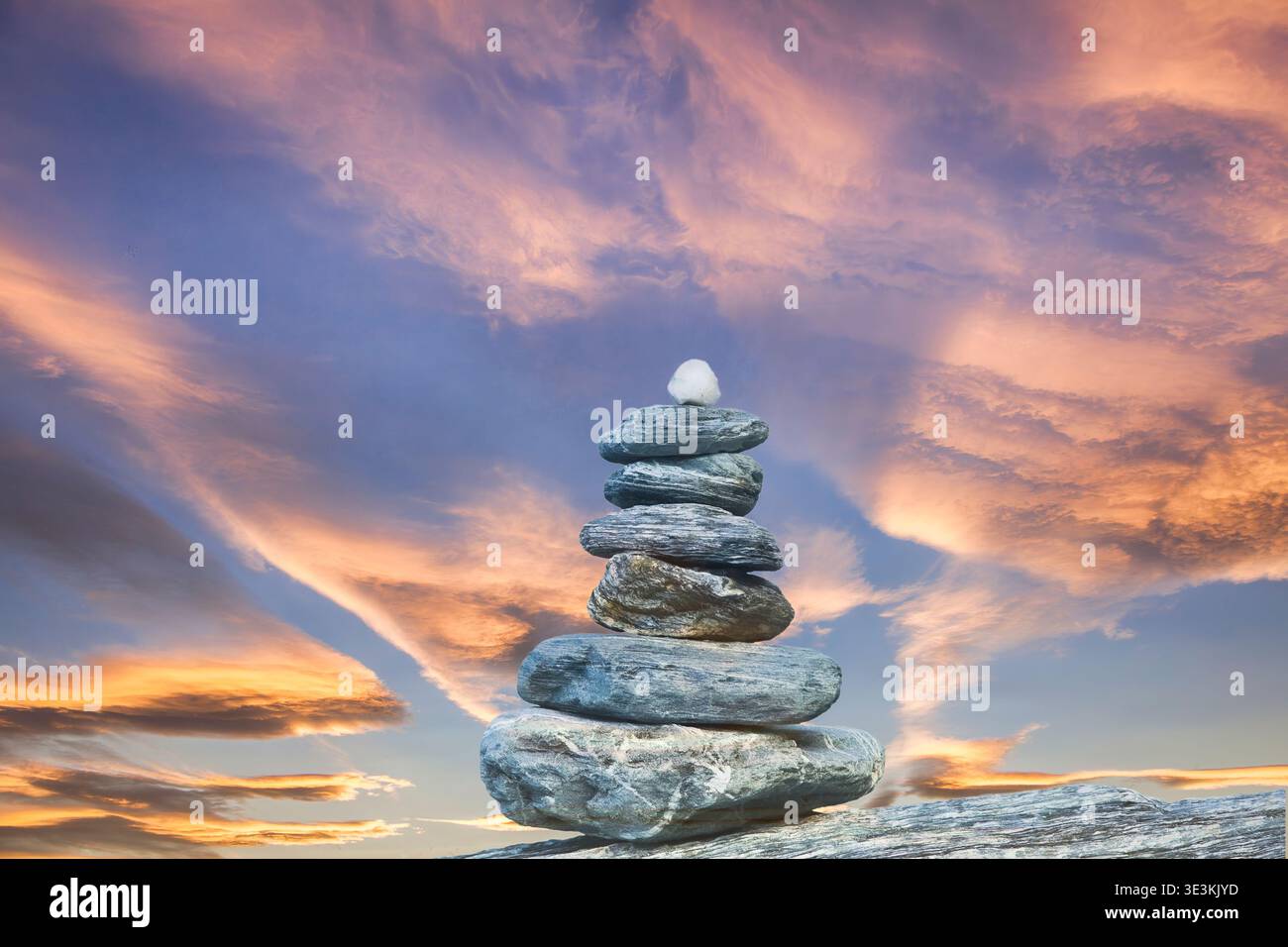 Stone cairn in front of sunrise sky. Concepts of new possibilities building on established grounds. Stock Photo