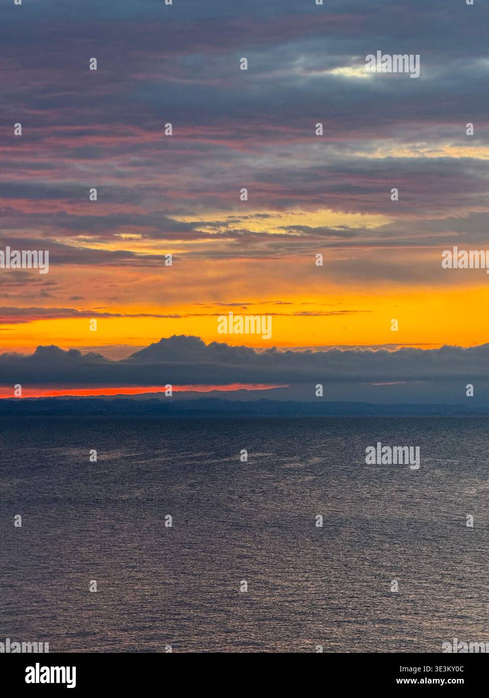 Dramatic red sunset over Lake Constance (Bodensee) with glowing clouds and calm water, tranquil evening seascape in Central Europe. - Smartphone Captured Stock Image