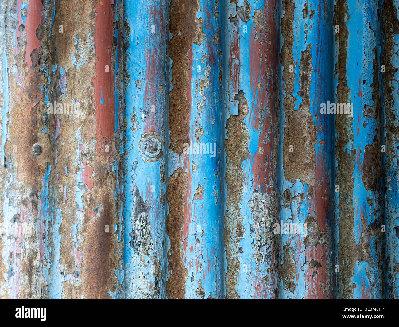 Rusted surface with bright blue tones and textured decay. Stock Photo