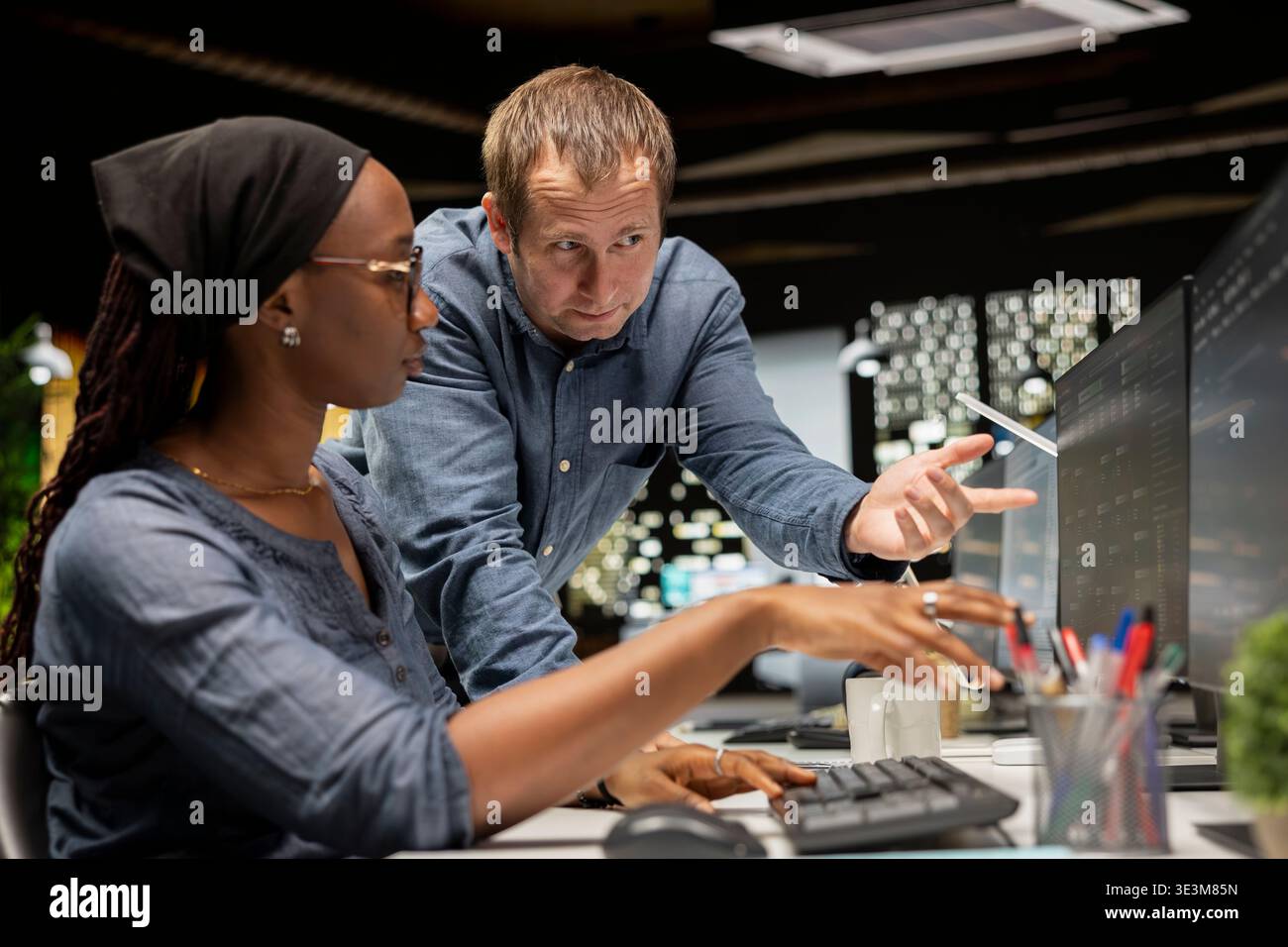 Team of programmers in tech startup office develop apps using AI machine learning automation. Coworkers working on PC, debugging applications with artificial intelligence Stock Photo