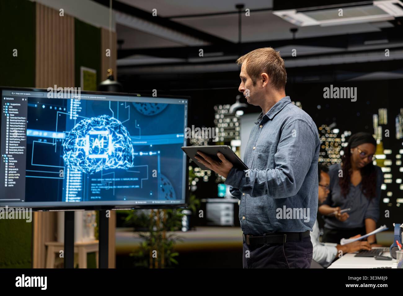 System administrator machine learning APIs developed by interns. Tech company team leader looking at large screen in tech startup to troubleshoot software errors using artificial intelligence Stock Photo