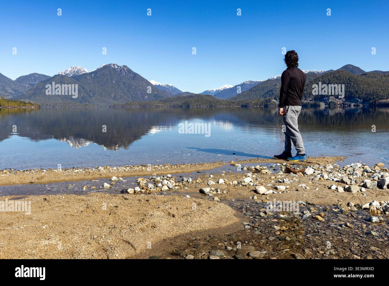 Hiker taking in the view of Kennedy Lake - Kennedy Lake Provincial Park, Vancouver Island, British Columbia, Canada Stock Photo