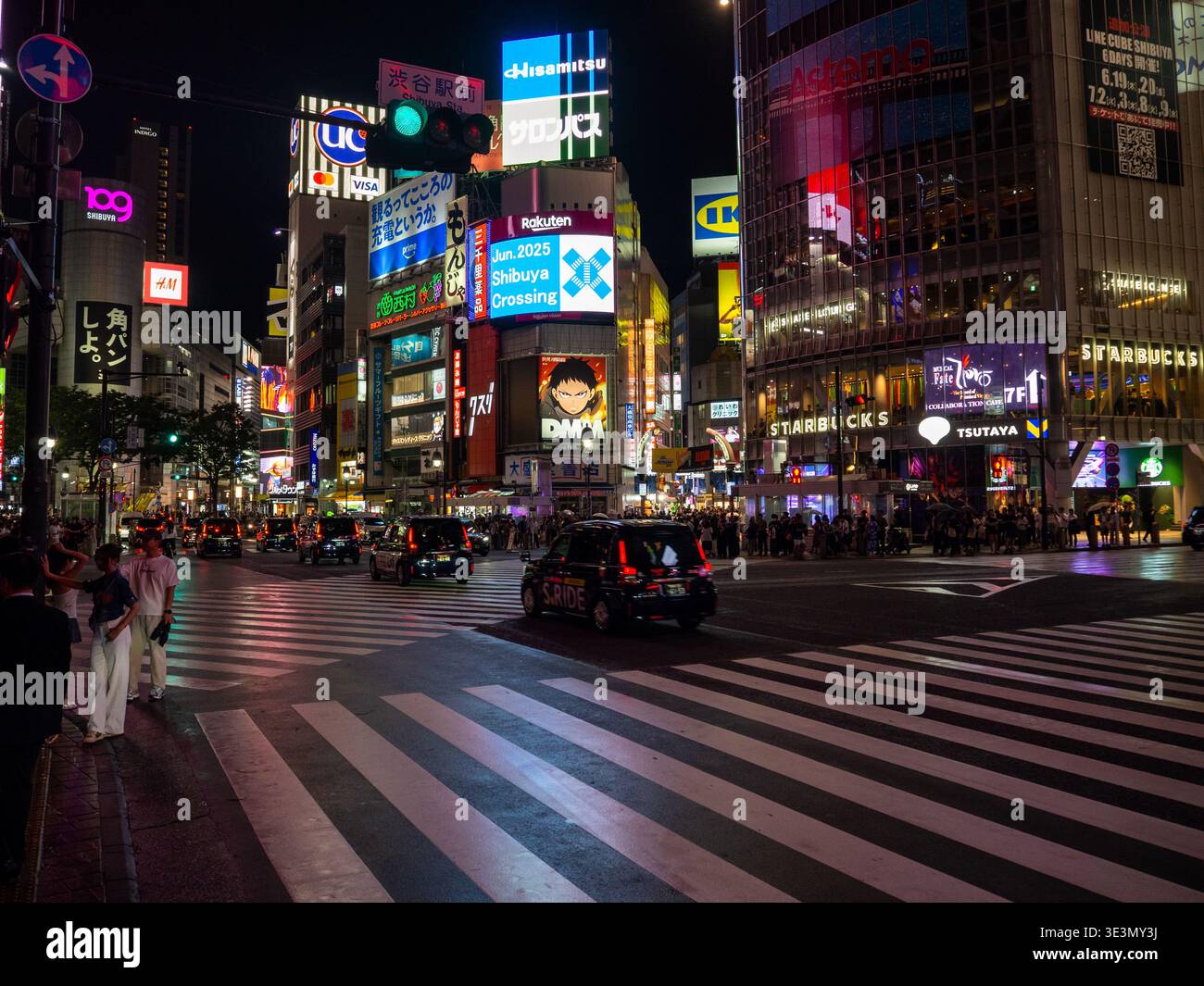 Nighttime crowded Shibuya Crossing in Tokyo with neon billboards