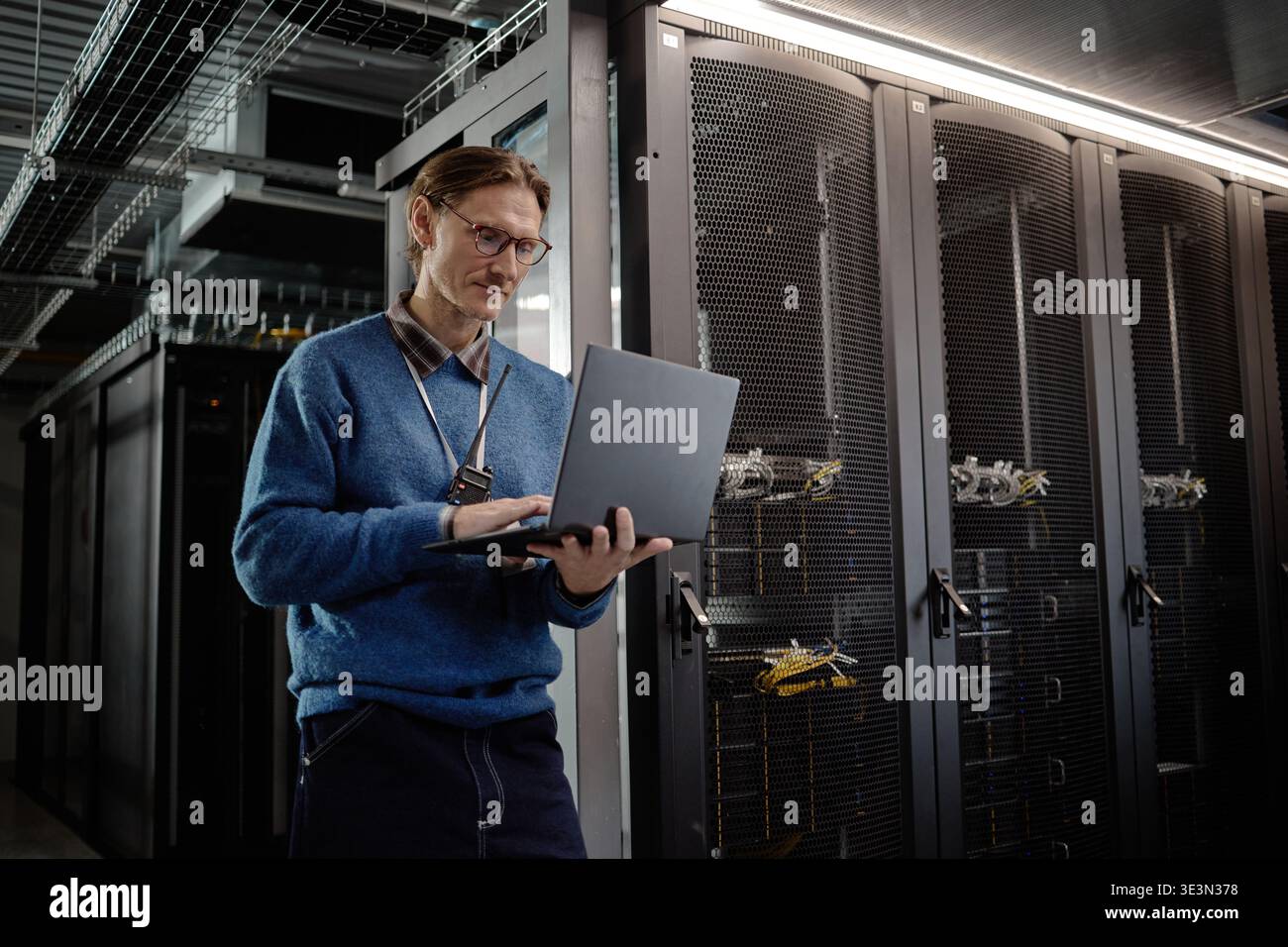 Caucasian Young Adult Man Using Laptop While Working Inside Data Center Stock Photo