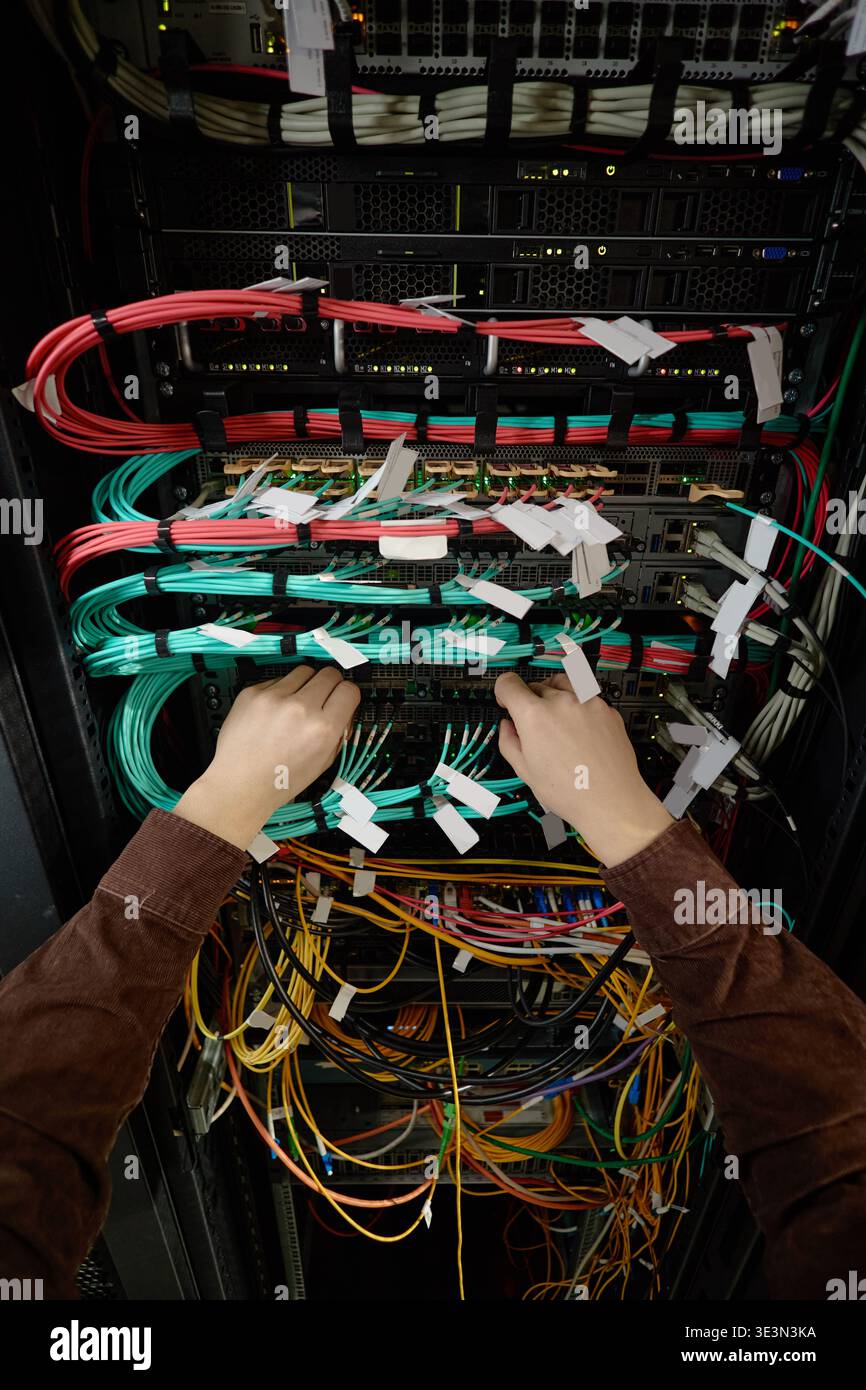 Man Configuring Network Cables in Data Center Rack Stock Photo