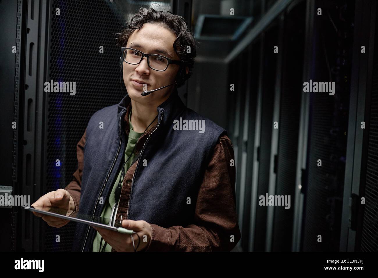 Portrait of Young Adult Asian Man Working with Tablet in Server Room Stock Photo