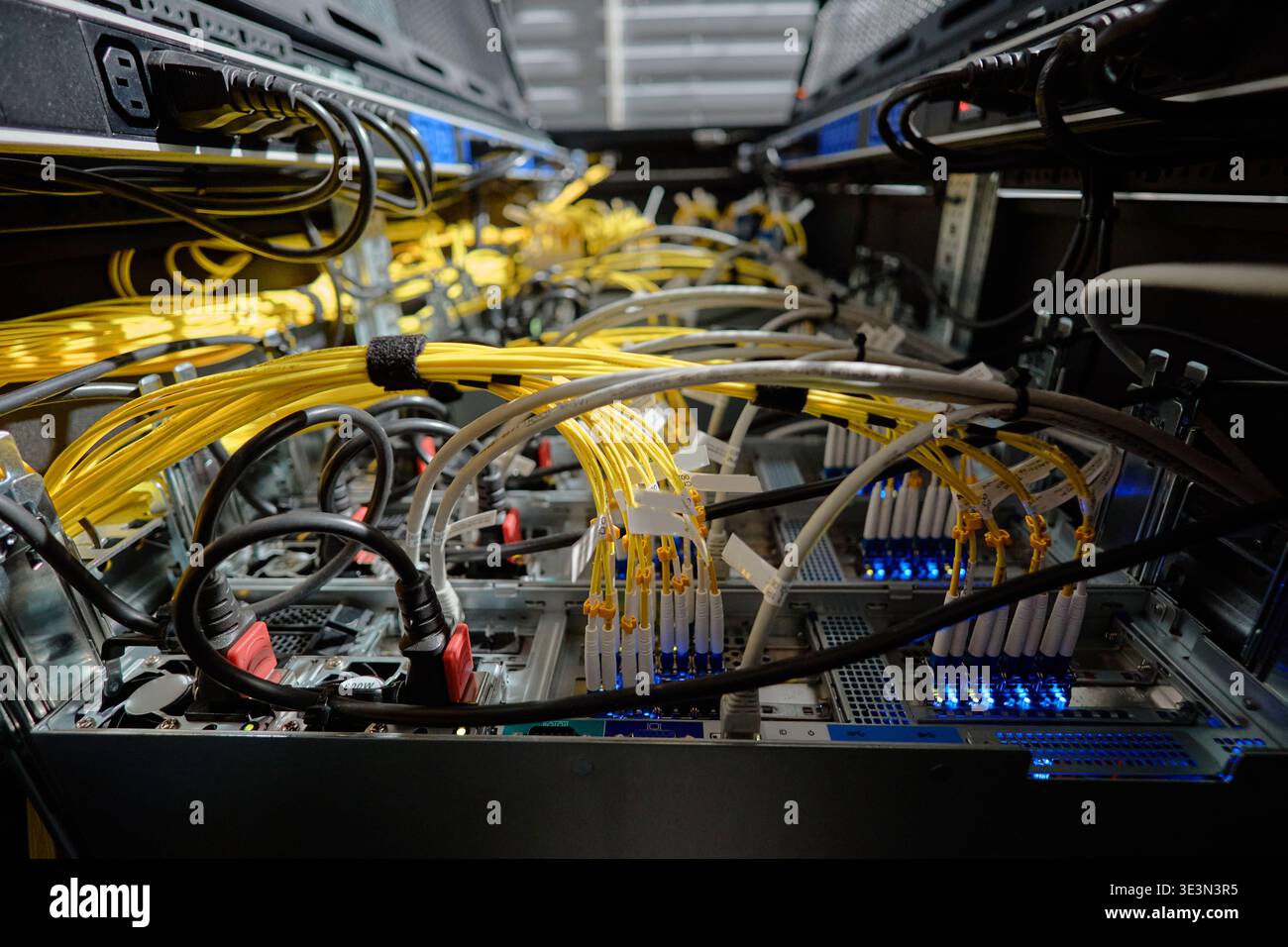 Network Servers Processing Data with Fiber Optic Cables in Data Center Stock Photo