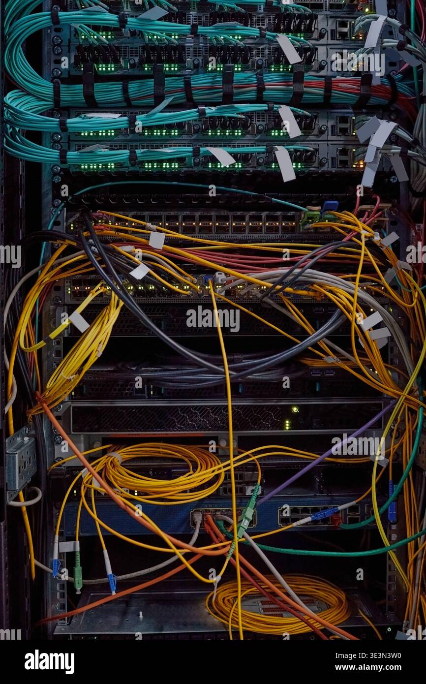 Network Server Rack Displaying Colorful Ethernet Cables and Blinking Lights Stock Photo