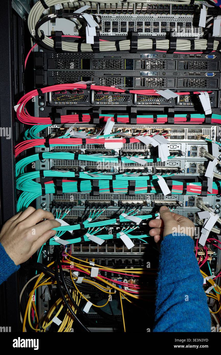 Unrecognizable Man Configuring Network Cables in Data Center Server Rack Stock Photo