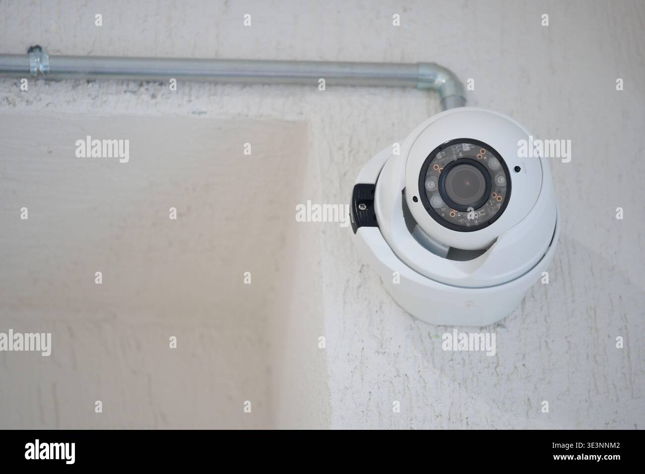 Security camera mounted on wall in indoor space Stock Photo