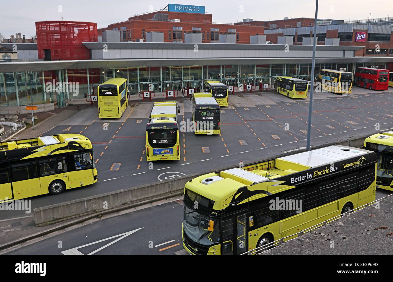 Warrington central Bus Interchange in Cheshire, filled with yellow Warrington’s Own Buses electric buses at the town centre transport hub. Stock Photo