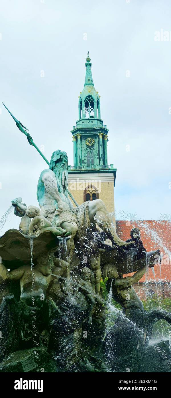 Berlin, Germany - August 16, 2025: . Neptune fountain features intricate sculptures with clock tower behind and water flowing - Smartphone Captured Stock Image
