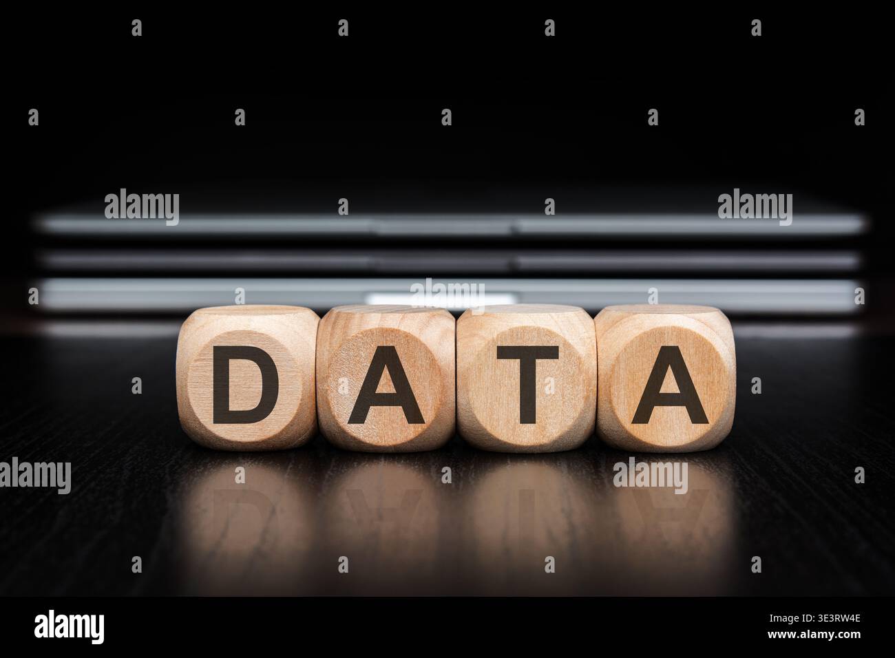 DATA word on wooden blocks with reflection and blurred laptops background. Big data, analytics, cloud computing and IT infrastructure concept. Stock Photo