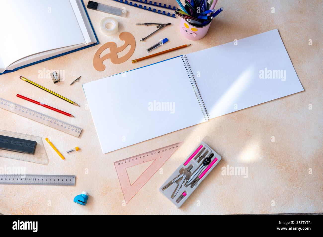 Blank spiral notebook with geometry drafting tools background. Various drawing instruments for school or engineering. Desk top view copy space Stock Photo