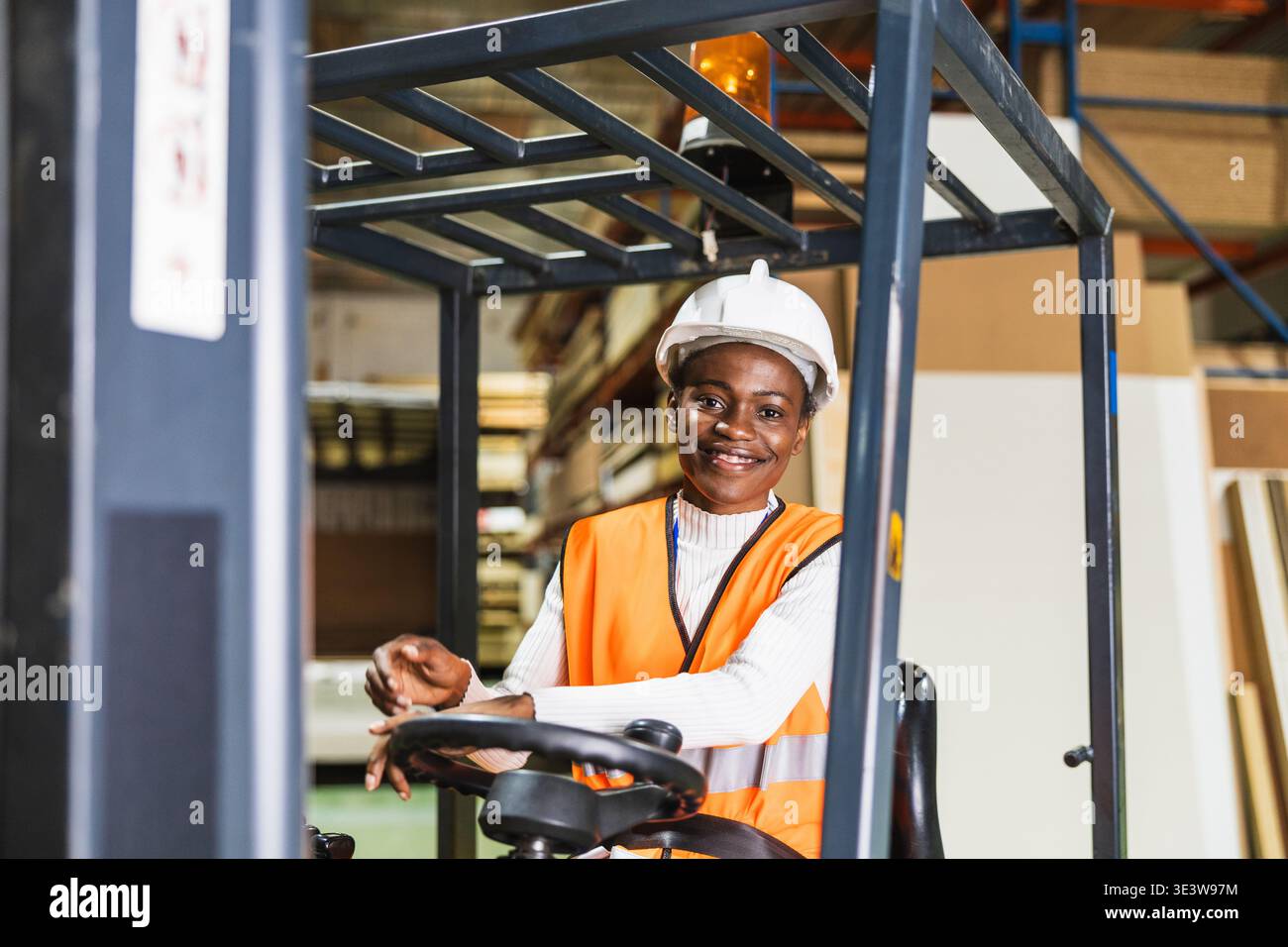 Female worker operating forklift in timber warehouse Stock Photo