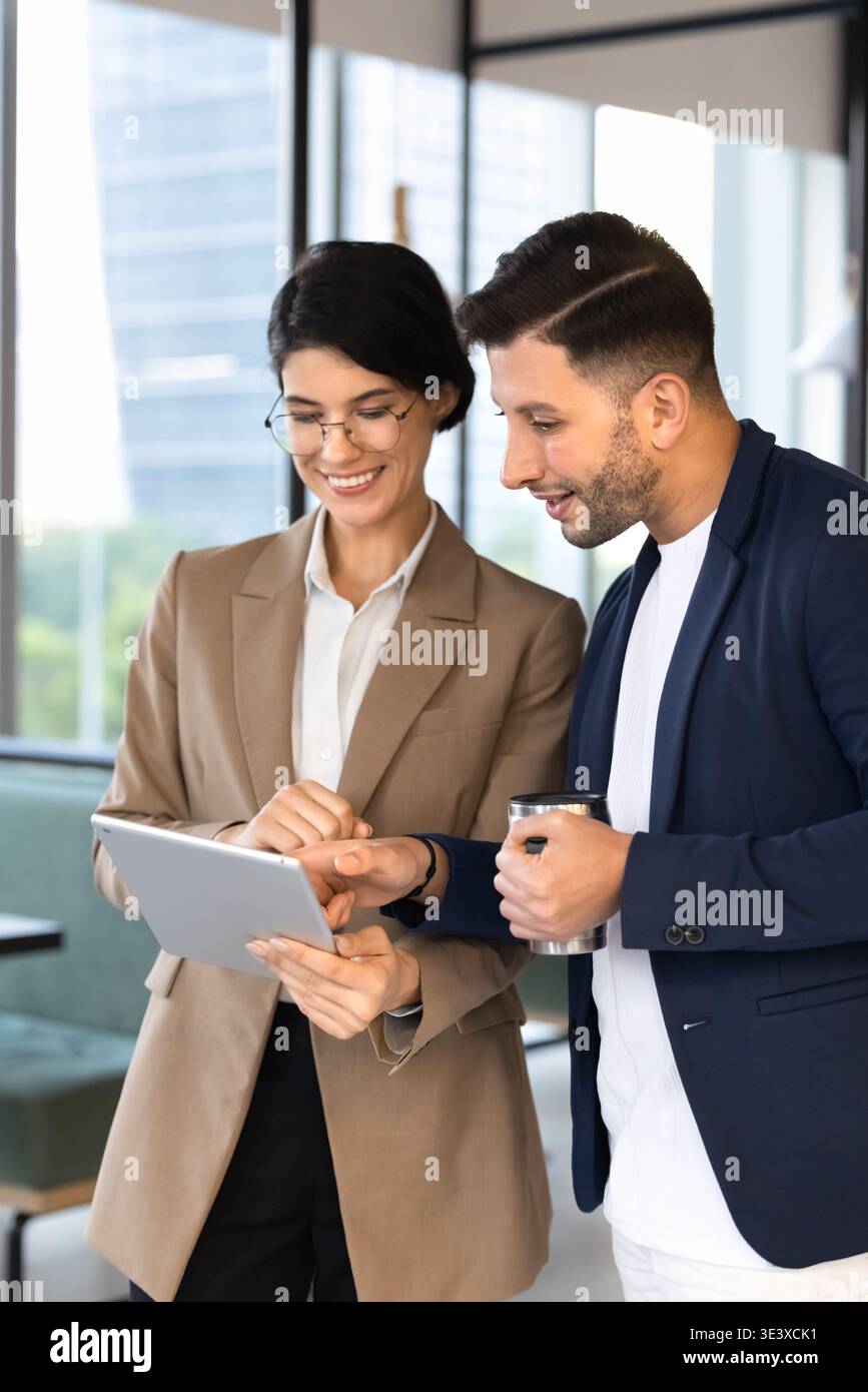 Two smiling colleagues discussing new business application on digital tablet Stock Photo