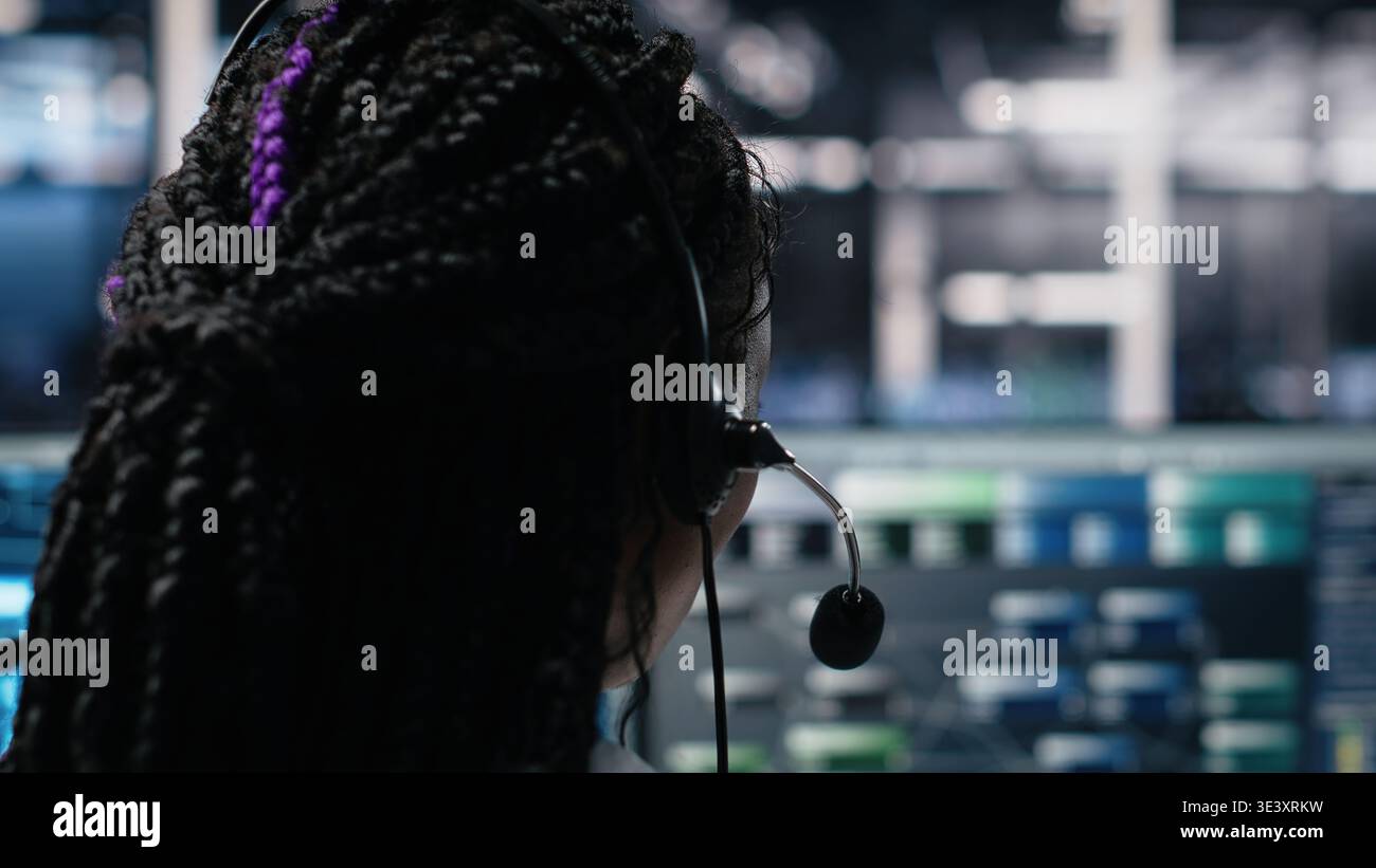 Data center admin using AI assistant to provide user technical support and solutions to users. Server farm IT expert managing live support calls assisted by artificial intelligence chatbot, camera A Stock Photo
